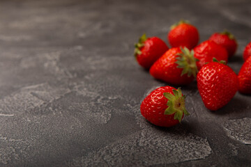 Fresh ripe strawberry on black texture background.Vegetarian organic berry.Healthy food.Copy space.Place for text