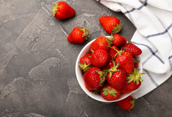 Fresh ripe strawberries in a plate on a black texture background.Vegetarian organic berry.Healthy food.Vitamins.Copy space.Place for text