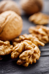 dried walnuts on a black rustic wooden background