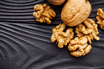 dried walnuts on a black rustic wooden background
