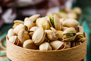 fresh salted pistachios on a wooden rustic background