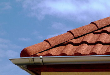 red brown sandy textured modern concrete roof tile closeup detail with half round ridge tiles....