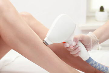 Diode laser hair removal, Beautician removes hair on female legs, laser procedure, Body care epilation treatment