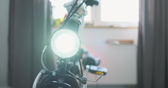 bicycle headlight shines into the camera. Bicycle steering wheel turns left to right. The concept of setting up a bike, fixing the light, demonstrating the operation of the headlight.