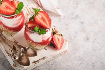 Strawberry Cheesecake. Cheesecake or trifle with strawberry in glass on old gray concrete background table background. Cheesecake without baking. Dessert. New York. Copy space. Food background.