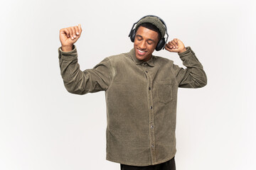 Relaxed cheerful latin man wearing and holding wireless headphones isolated on white wall, enjoying listening to favourite music soundtrack, wellbeing concept