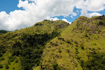 Obraz premium Aerial drone of Mountains with green grass and forest against the blue sky and clouds. Mountain landscape in Sri Lanka.