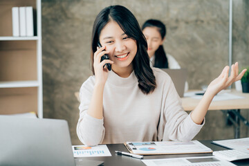 Asian businesswoman in formal suit in office happy and cheerful during using smartphone and working