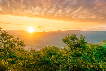 graet highland landscape with scenic view from mountain to below to a walley with majectic mountains and scenic cloudy sunset on background