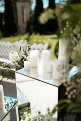 Close up of wedding decorations, with white fresh flowers. Tender wedding arrangements. White candles