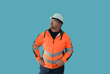 Focused looking man in yellow helmet orange reflective jacket looking to the side