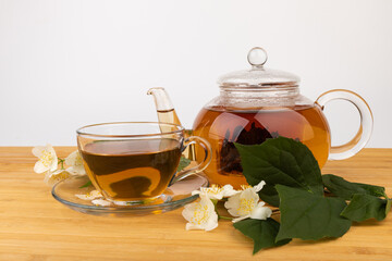 Composition with cup of jasmine tea and flowers on light background
