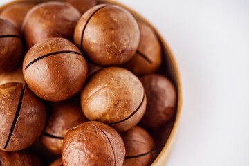 fresh macadamia nuts on a white acrylic background