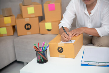 business owner hand writing on parcel boxes