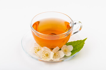 Composition with cup of jasmine tea and flowers on light background