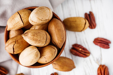 delicious fresh pecans on a white wooden rustic background