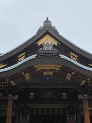 Fototapeta premium The main pagoda of Yushima Tenjin, the historic establishment in 458 the beautiful architecture with plum symbolic family crest “Kamon”. Photo taken year 2022 June 15th