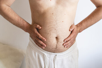 Close up of fat man's belly. Perhaps the concept of abdominal pain, bloating. Health concept.