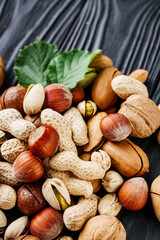 set of different nuts on a black rustic wooden background