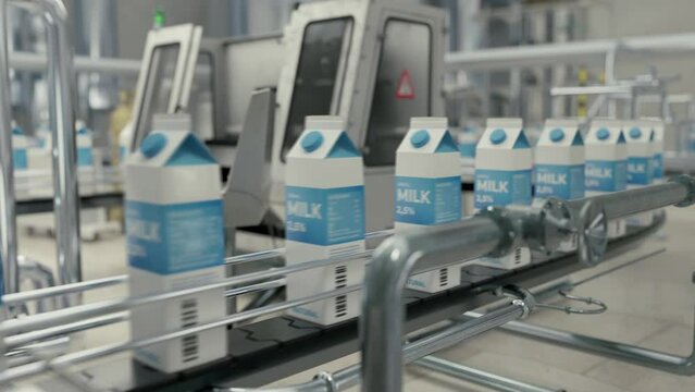 Conveyor machinery carrying the packaged milk products at the factory. Packages with dairy products advancing on a conveyor machinery. Automated conveyor machinery dealing with food packaging.