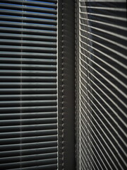Abstract background. Blinds on the window and a pattern of shadow and light on the wall.