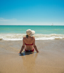 Fototapeta na wymiar Brunette woman enjoying a sea foam bath on the shore of the beach.
