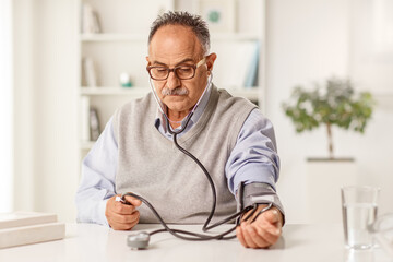 Mature man measuring blood pressure