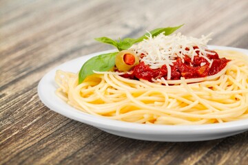 spaghetti pasta in a white plate with ketchup sauce