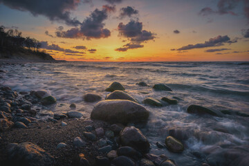 Naklejka premium Colorful sunset on the sea rocky shore