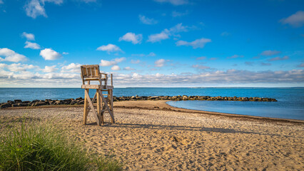Seascape with the lifeguard bench at sunrise on the Cape Cod beach in Falmouth, Massachusetts.
