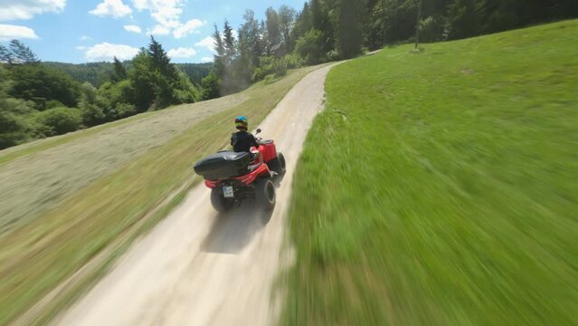 ATV quad bike on a forest macadam path - an attractive shot of pursuit with an FPV drone #3