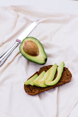 avocado cut in half. avocado on a white background. sliced avocado on bread.