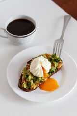 guacamole. mexican cuisine. avocado sauce. guacamole on black bread. sandwich with guacamole sauce and poached egg.