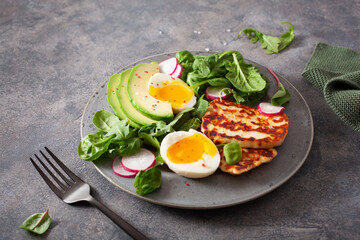 healthy keto paleo diet breakfast: boiled egg, avocado, halloumi cheese, salad leaves