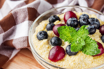 sweet porridge with quinoa and berries on a wooden rustic background
