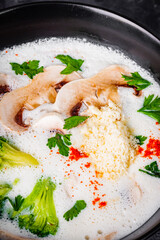 creamy mushroom soup with champignons on a black background
