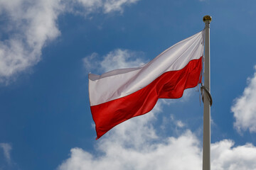 Fototapeta na wymiar The flag of Poland flutters against the sky