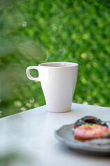 Relaxing americano coffee in white porcelain cup on stone table