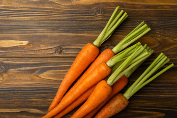 Fresh carrots on brown texture background. Ingredient for salad.Vegetarian organic vegetables.Healthy food.Copy space.Place for text