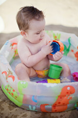 Baby boy in childs swimming pool
