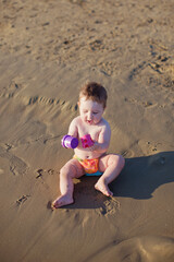 Fototapeta na wymiar Baby boy sitting on beach sea