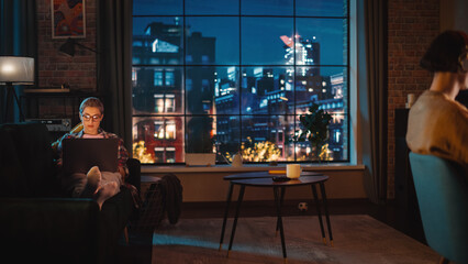 Young Couple Spending Time at Home, Working on Computers from Their Stylish Loft Apartment in the...