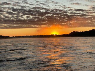 sunset over river in perus rainforest