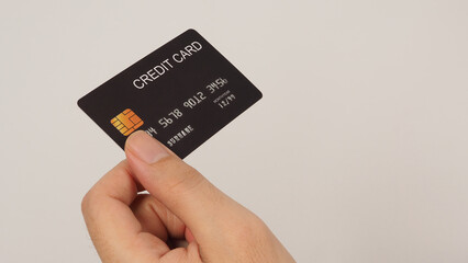 Hand is holding black credit card isolated on white background..