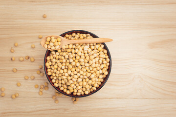 soybean in a bowl with wooden spoon on wooden background, top view, flat lay, top-down, selective focus.copy space.