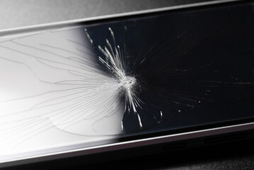 Broken glass background with bullet hole over black background. Shattered and broken glass pieces with hole scattered glass. Macro photography. phone broken glass