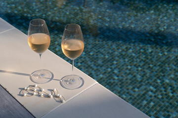 Two glasses of rose wine by the pool.