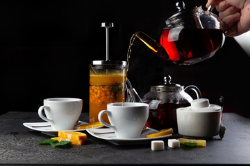 Tea is poured into a cup on a dark background.