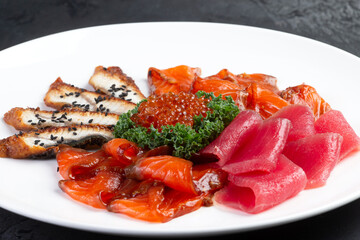 Assorted fish cut into slices. Salmon, eel, tuna, trout. Decorated with red caviar.