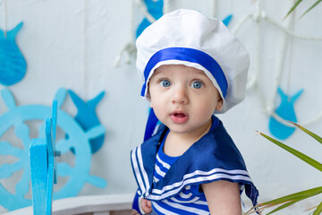baby in the sea zone with a ship in a sailor's vest, the concept of summer and travel